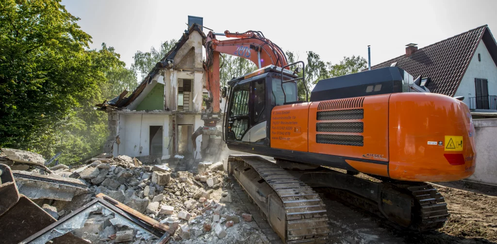 Bagger von Entsorgungsunternehmen Zens reißt ein Haus im Raum Karlsruhe ab. Abbrucharbeit
